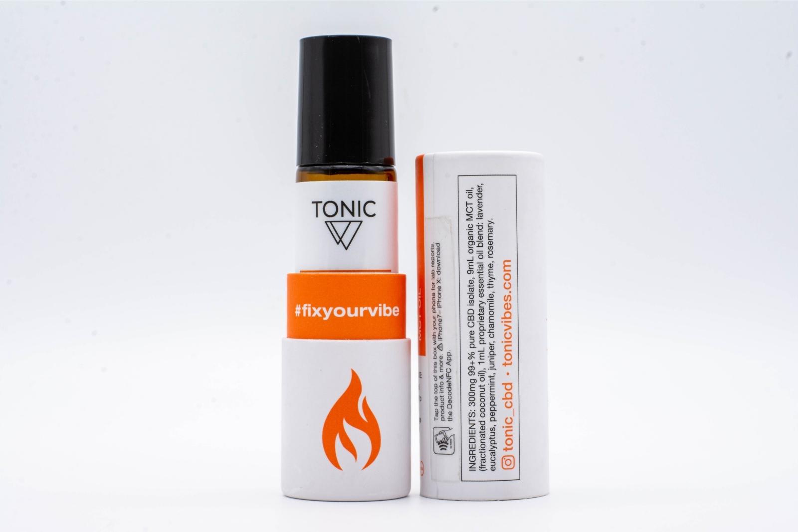 An open container of Tonic's Chronic CBD + Essential oil roll-on, showing the bottle and the ingredients, on a white background