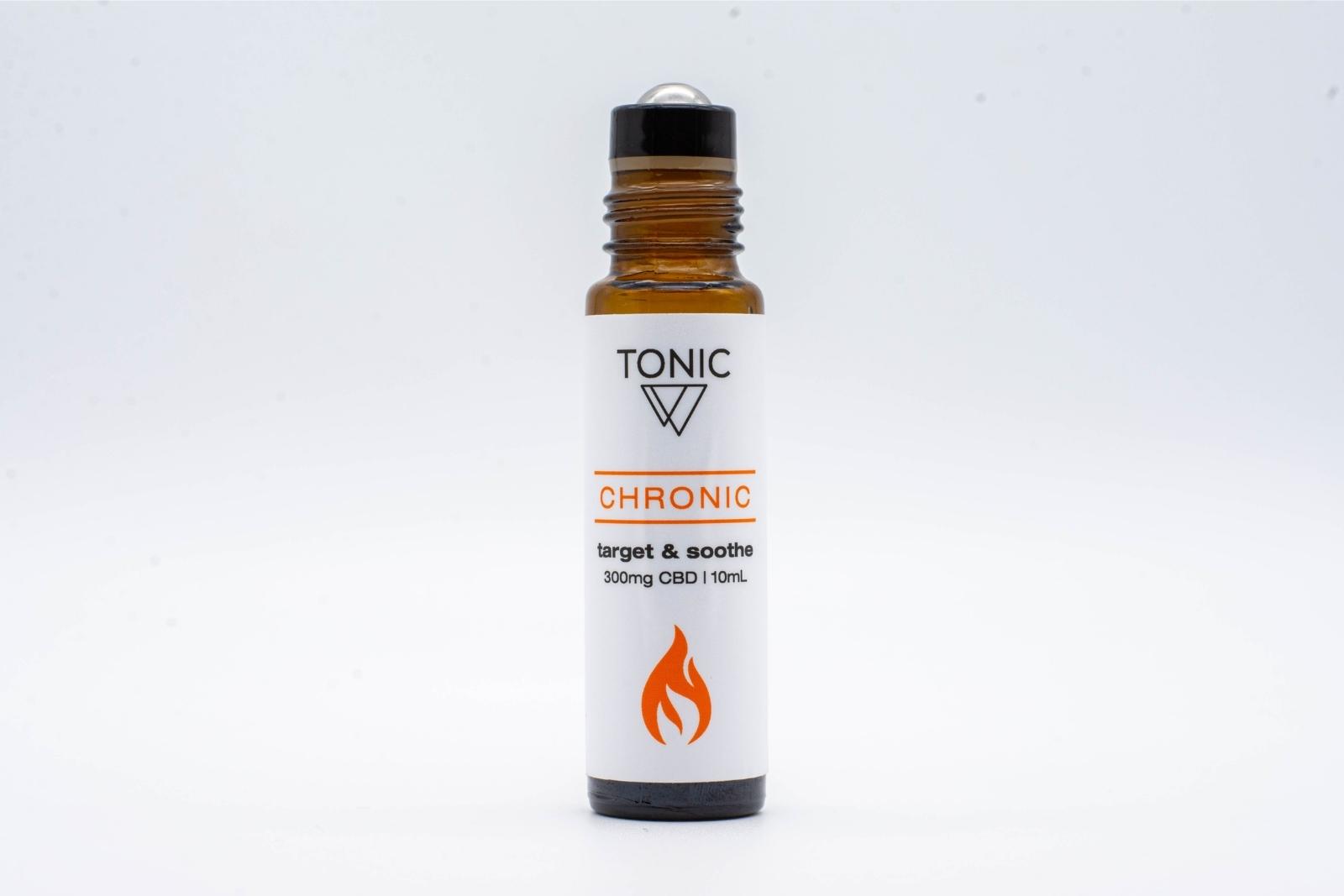 A bottle of Tonic's Chronic CBD + Essential oil roll-on with its top removed to show the roller-ball applicator, on a white background