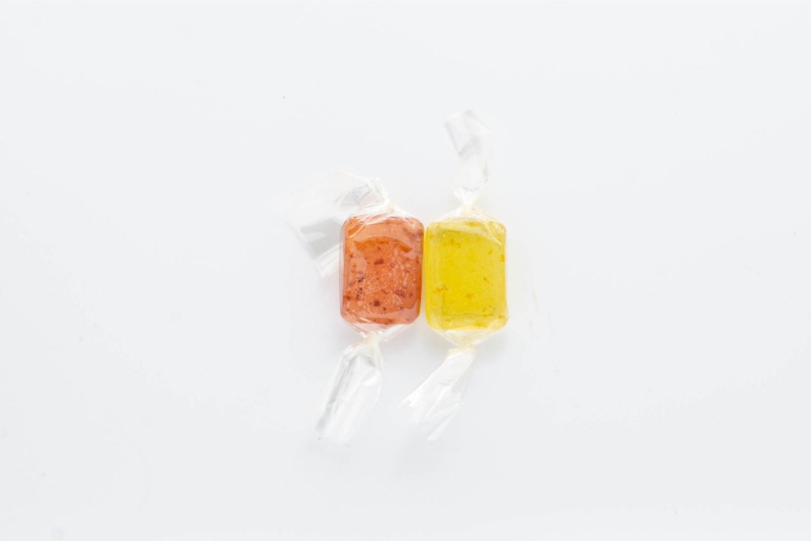 The two varieties of Nice 1:1 hard candies, tart cherry and lemon, on a white background