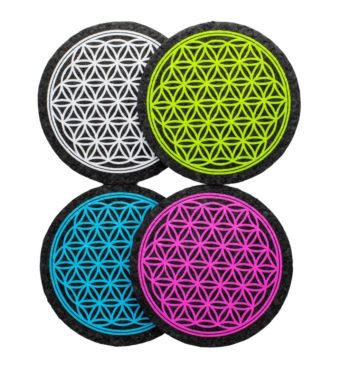 Four colors of Flower of Life rubber dab mats by East Coasters, on a clear background