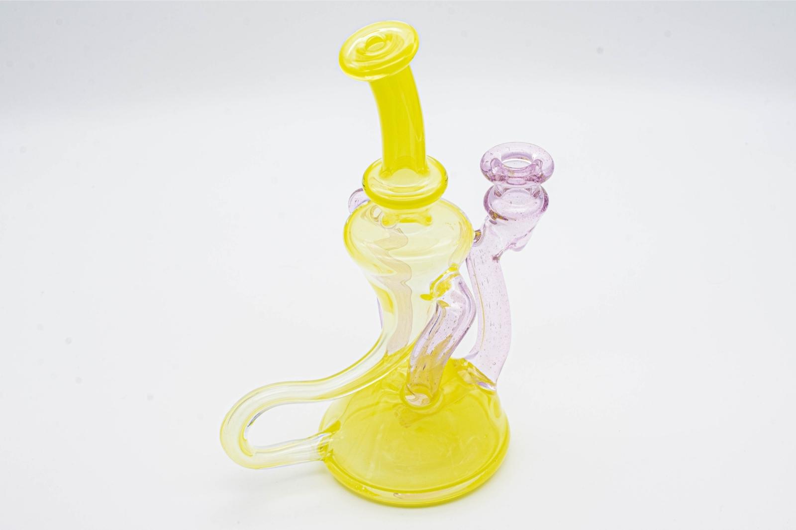 A yellow and pink dual recycler by Quasi Glass, on a white background