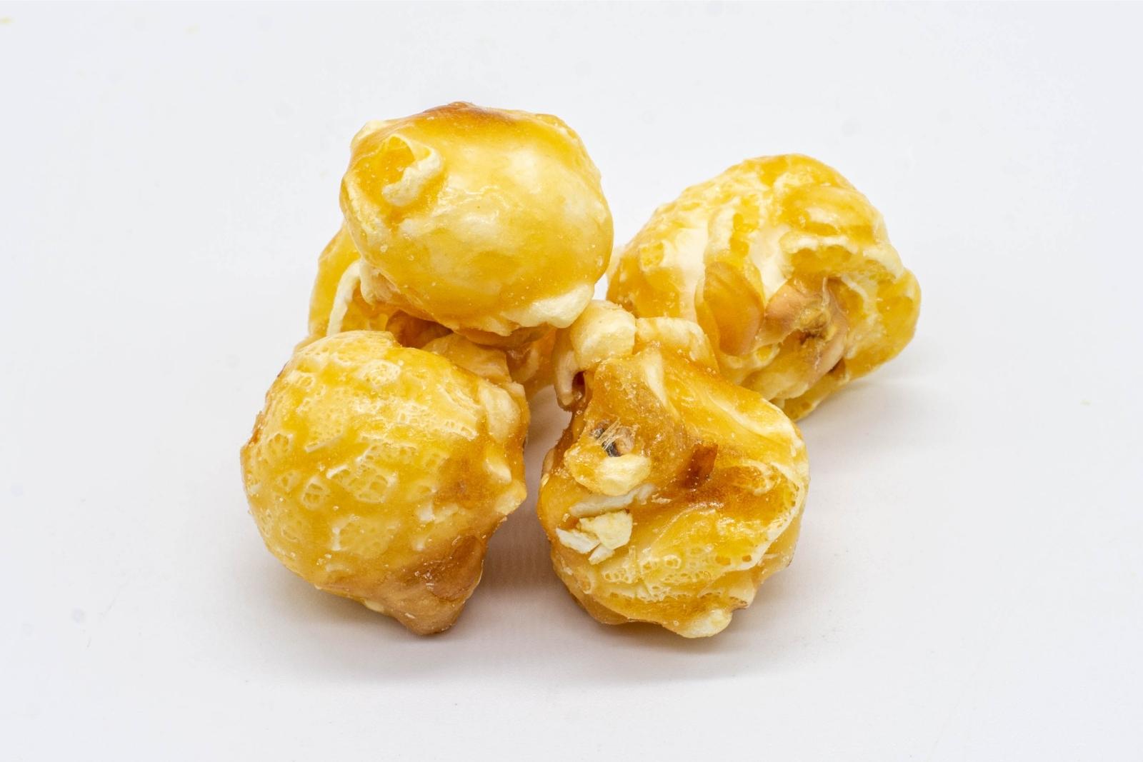 A small pile of loose 1:1 Caramel Popcorn, made by XITE, on a white background