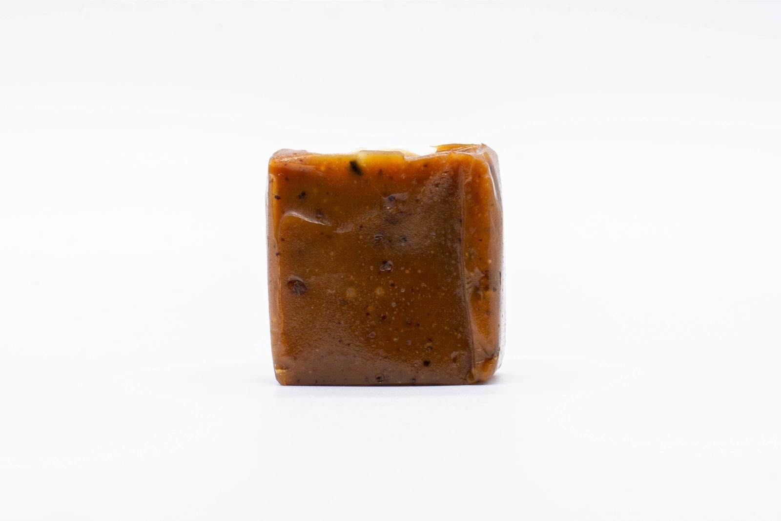 An unwrapped 2:1 Coffee Crunch Caramel by Seventh Hill CBD, on a white background