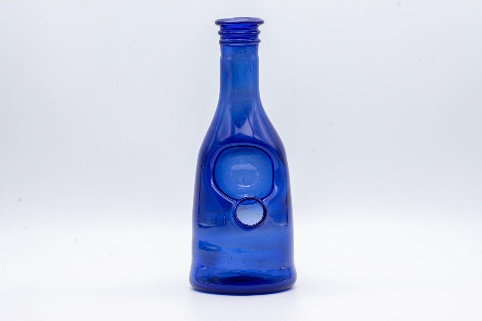 A blue sake bottle rig by Costa Glass, on a white background
