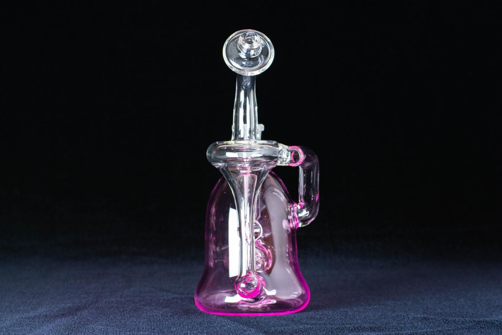 A pink 7-inch recycler made by Jack Glass Co., on a black background