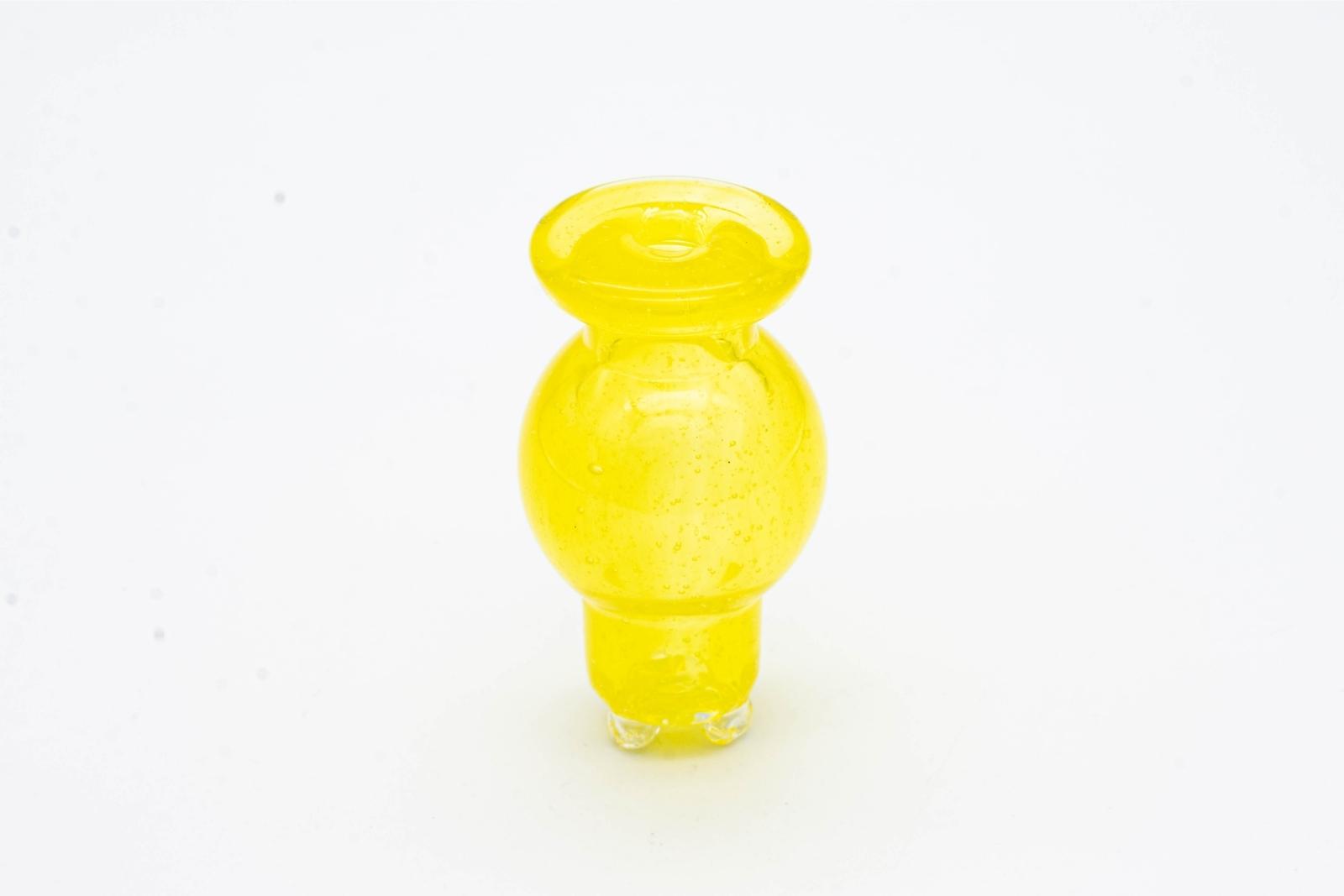 A yellow spinner bubble cap made by BorOregon, on a white background