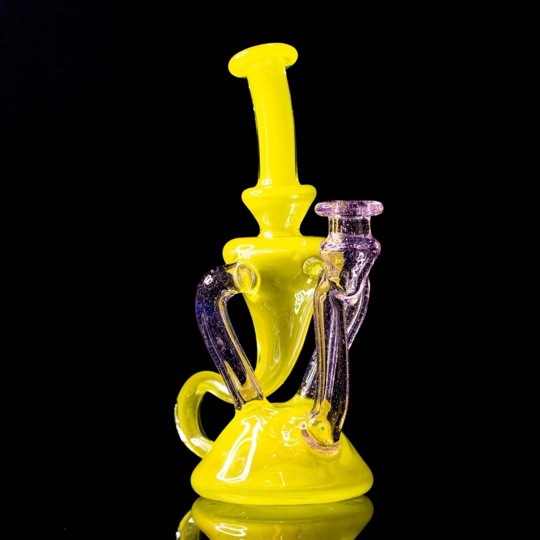A yellow and pink dual recycler by Quasi Glass, on a black background