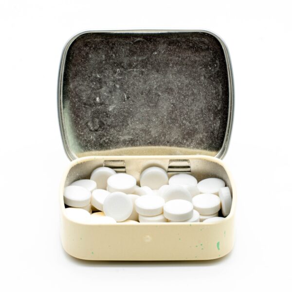 The inside of an open container of Wintergreen THC Mints by Cycling Frog, on a white background