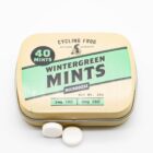 One container of Wintergreen THC Mints by Cycling Frog, next to a small pile of the mints, on a white background
