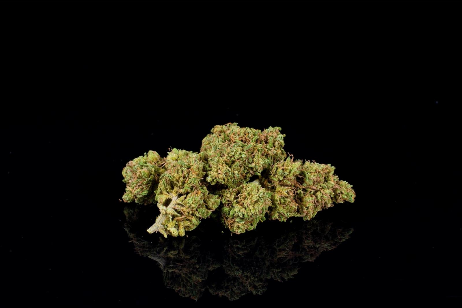 A pile of nugs of Cherry Crème Brulee hemp flower by Holy City Farms, on a black background