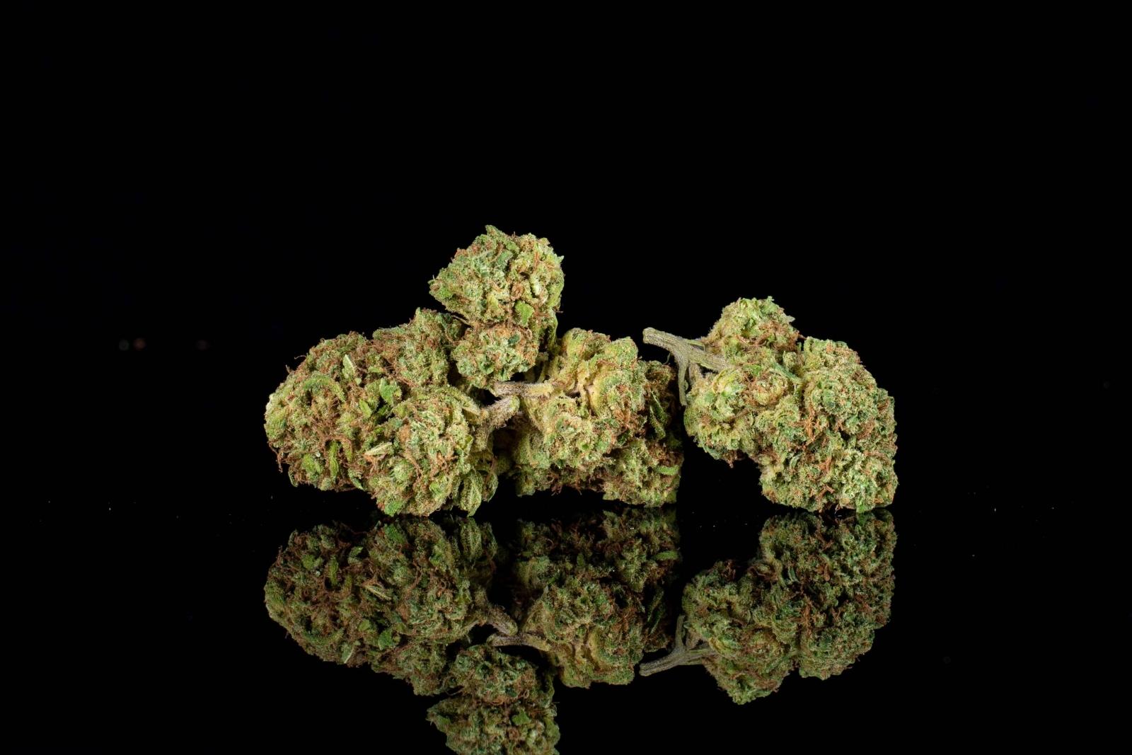 A group of nugs of Blueberry hemp flower by Holy City Farms, on a black background