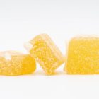 A pile of Sativa Hybrid Gummies by Seventh Hill CBD, on a white background