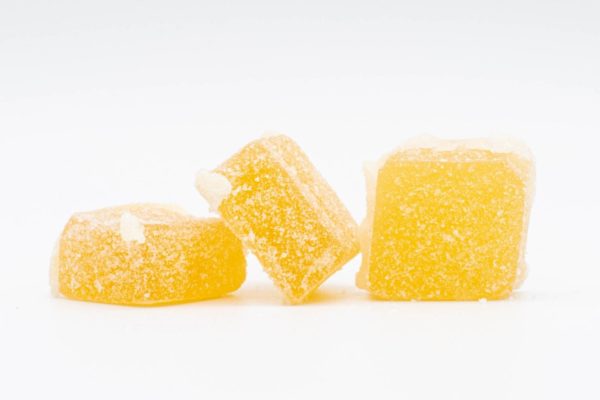 A pile of Sativa Hybrid Gummies by Seventh Hill CBD, on a white background
