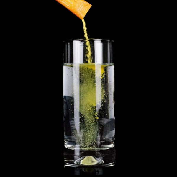 Brelixi Nano THC Infused Drink Mix being poured into a glass of water, on a black background.