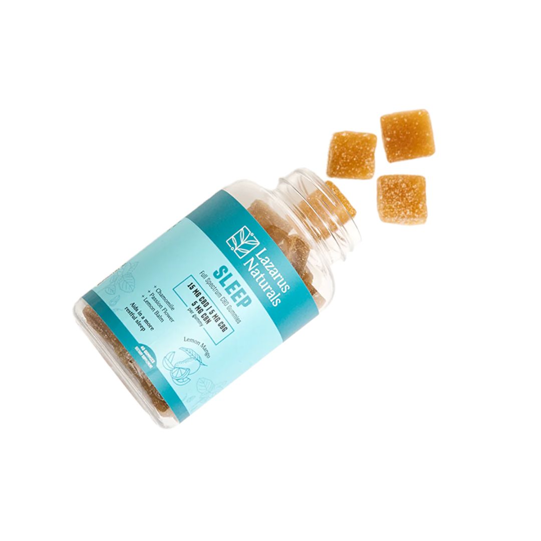 A bottle of Lazarus Naturals CBD Sleep Gummies on its side with gummies pouring out because the lid is off.