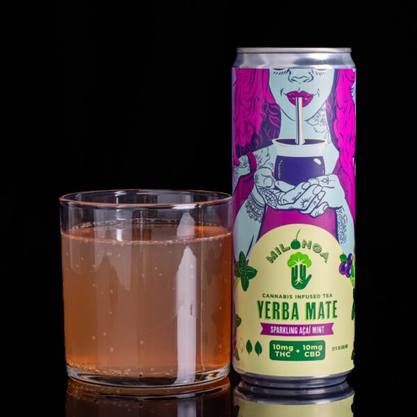 A single can of sparkling acai mint flavored Milonga Infused Yerba Mate, next to a clear glass container containing the drink, on a black background