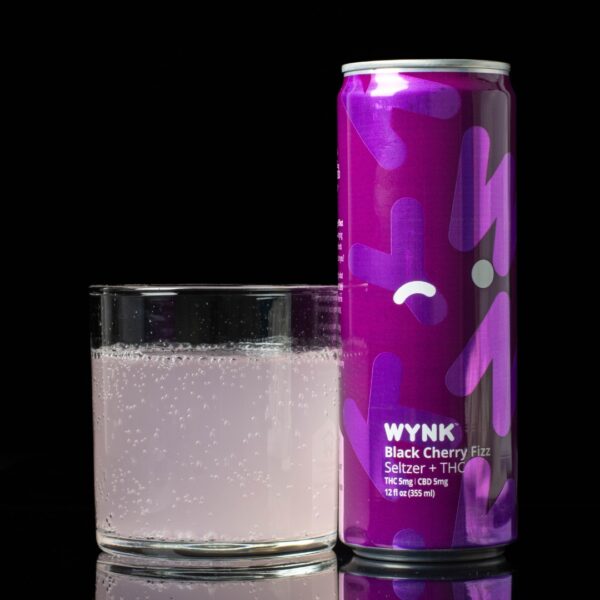 A single can of Black Cherry Fizz flavored WYNK Infused Seltzers, next to a clear glass container containing the drink, on a black background