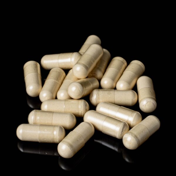 A small pile of Plant Science Laboratories Capsules- CBD, on a black background